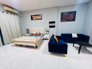 a living room with a bed and a couch at Studio Apartment in Ajman 