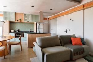a living room with a couch and a kitchen at Outside Home Apto próx USP in Bauru