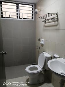 a bathroom with a toilet and a sink at KASTURI GUEST HOUSE PUTRAJAYA in Putrajaya