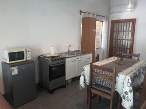uma cozinha com um fogão, um micro-ondas e uma mesa em Casa acogedora y funcional em Atlántida