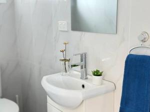 a bathroom with a white sink and a blue towel at Convenient 2 Bedroom house unit in Salisbury in Brisbane +8 photos