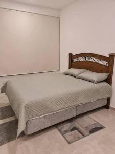 a bed in a room with a white wall at Cerca de Shopping Mariscal López in Asuncion +17 photos