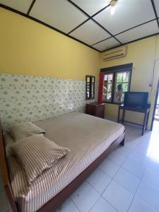 a bedroom with a bed and a desk in it at Jogja Inn in Timuran