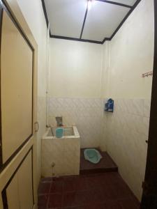 a small bathroom with a toilet and a door at Jogja Inn in Timuran