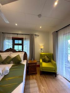 a bedroom with a bed and a yellow chair at Benjamine's Guesthouse in La Digue +116 photos