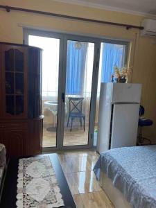 1 dormitorio con nevera y puerta corredera de cristal en Квартира на пляже, en Durrës