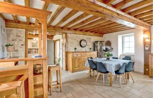 cocina y comedor con mesa y sillas en Amazing Home In Ltang-bertrand With Outdoor Swimming Pool, en L'Etang-Bertrand