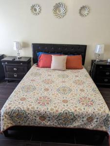 um quarto com uma cama grande e 2 mesas de cabeceira em Espectacular apto, acogedor para un feliz descanso em Tegucigalpa