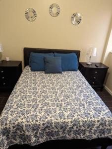 1 dormitorio con 1 cama con almohadas azules y relojes en la pared en Espectacular apto, acogedor para un feliz descanso, en Tegucigalpa