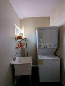 a bathroom with a sink and a tv on top of a refrigerator at Espectacular apto, acogedor para un feliz descanso in Tegucigalpa
