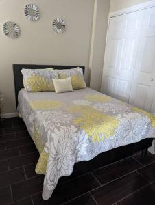 a bedroom with a bed with a yellow and white blanket at Espectacular apto, acogedor para un feliz descanso in Tegucigalpa