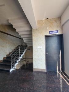 RāmanagaramにあるRoyal Residencyの階段と青いドアのある廊下