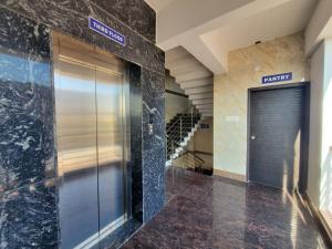 RāmanagaramにあるRoyal Residencyの壁面の看板のある建物内のエレベーター