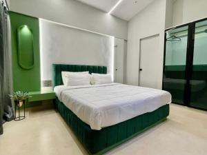 a bedroom with a large bed with a green headboard at Dreamview Mountains - Cozy 1bhk with Sunrise view in Karjat +21 photos