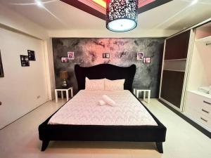 a bedroom with a large bed with pink sheets at Sheryll Escapes - Kandi luxury 1BR, housekeeping & Netflix! in Angeles