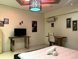 a bedroom with a bed and a desk and a television at Sheryll Escapes - Kandi luxury 1BR, housekeeping & Netflix! in Angeles
