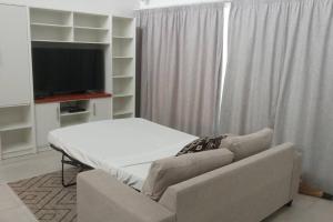One bedroom Executive Apartment - 8 في سوفا: غرفة معيشة مع أريكة وتلفزيون بشاشة مسطحة