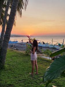 a woman standing on the beach looking at the sunset at Tejakula Sunset Boutique Resort in Tejakula