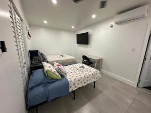 a bedroom with two beds and a table and a tv at LYZ Miami Airport in Miami