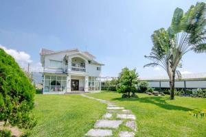 una casa blanca con una palmera y una pasarela en Star House, en Tianfu