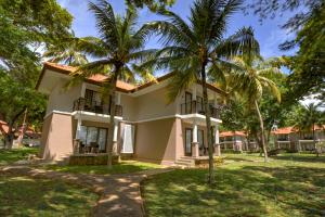 a house with two palm trees in front of it at Mambruk Hotel & Convention in Serang