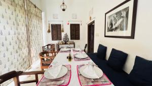 a dining room with a table and a couch at Mosaics Guest House in Jaipur