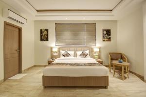 a bedroom with a large bed and a window at Hotel AMBS suites A family Hotel Near Delhi Airport in New Delhi