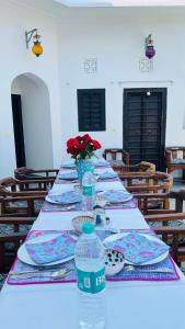 a long table with plates and water bottles on it at Mosaics Guest House in Jaipur
