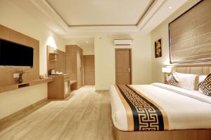 a hotel room with a bed and a flat screen tv at Hotel AMBS suites A family Hotel Near Delhi Airport in New Delhi