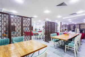 a dining room with wooden tables and chairs at RICH PARK HOTEL in Tashkent