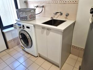 a kitchen with a sink and a washing machine at Port Elliot Beachcomber on Horseshoe Bay linen included spotless in Port Elliot +23 photos