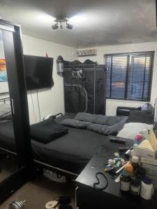 a room with two beds and a desk and a tv at Litchport in London