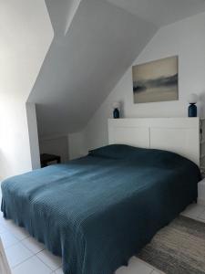 - une chambre avec un lit et une couverture bleue dans l'établissement T2 Cozy Rungis - 15min de Paris !, à Rungis