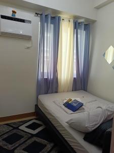 a bed in a room with blue curtains at Doroin Krib Staycation in Manila