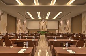 a conference room with tables and chairs and a podium at Mambruk Hotel & Convention in Serang