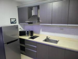 uma cozinha com um lavatório e um frigorífico em Kandi studio by the pool. Housekeeping, Netflix! em Angeles
