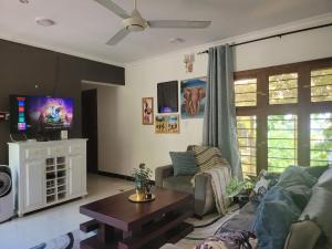 ein Wohnzimmer mit einem Sofa und einem TV in der Unterkunft Funvilla Family House in Daressalam