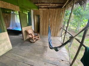 una habitación con una hamaca y una silla en una casa en Buchisapa Lodge, en Iquitos