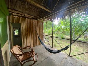 una hamaca y una silla en un porche en Buchisapa Lodge, en Iquitos