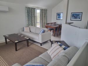a living room with a couch and a table at Port Elliot Beachcomber on Horseshoe Bay linen included spotless in Port Elliot
