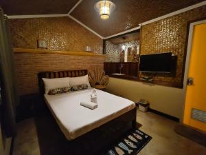 a bedroom with a large bed with a television at Forest wood-Port Barton in San Vicente