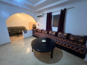 a living room with a couch and a table at Apparentement 3 meublée 1er étage in Oujda