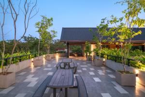 un patio con bancos, árboles y luces en Thimbiri Wewa Resort Wilpattu en Wilpattu