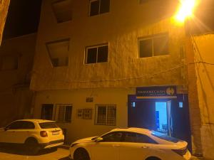 two cars parked in front of a garage at night at Apparentement 3 meublée 1er étage in Oujda