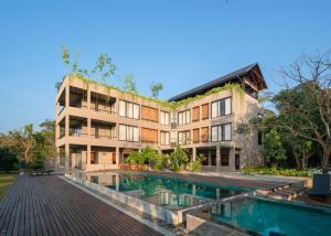 - un bâtiment avec une piscine en face dans l'établissement Thimbiri Wewa Resort Wilpattu, à Wilpattu