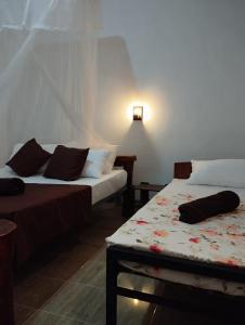 Cette chambre comprend 2 lits et une table. dans l'établissement Eco Pavilion, à Sigirîya