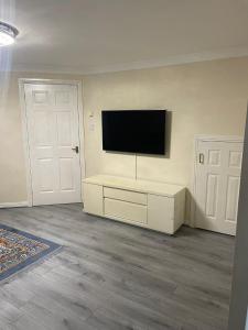 a living room with a flat screen tv on a wall at 3-Bedrooms House in Thornliebank Glasgow in Mansewood