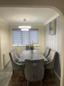 a dining room with a table and chairs and a chandelier at 3-Bedrooms House in Thornliebank Glasgow in Mansewood