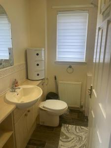 a bathroom with a white toilet and a sink at 3-Bedrooms House in Thornliebank Glasgow in Mansewood