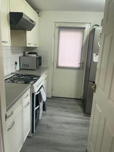 eine Küche mit einem Herd und einem Kühlschrank in der Unterkunft 3-Bedrooms House in Thornliebank Glasgow in Mansewood